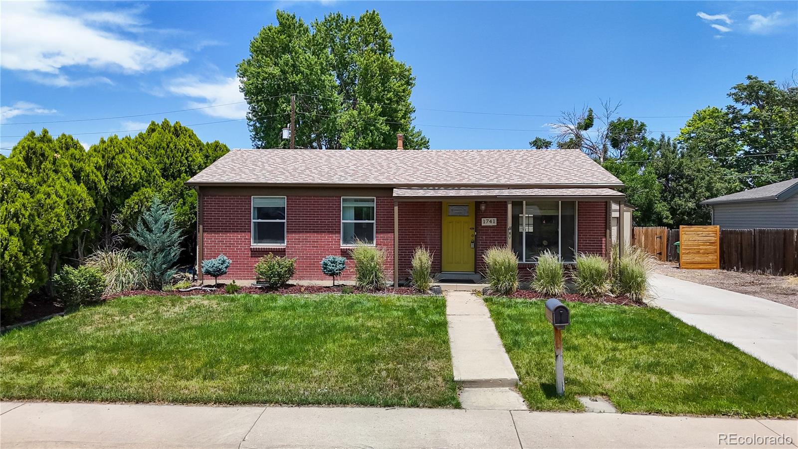 1741 West 55th Place Denver, CO 80221 - Photo 27 of 36 a front view of a house with a yard and trees