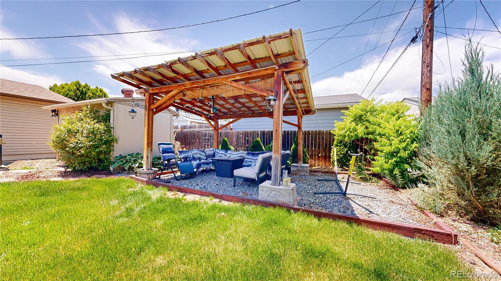 1741 West 55th Place Denver, CO 80221 - Photo 32 of 36 a view of a backyard with table and chairs under an umbrella