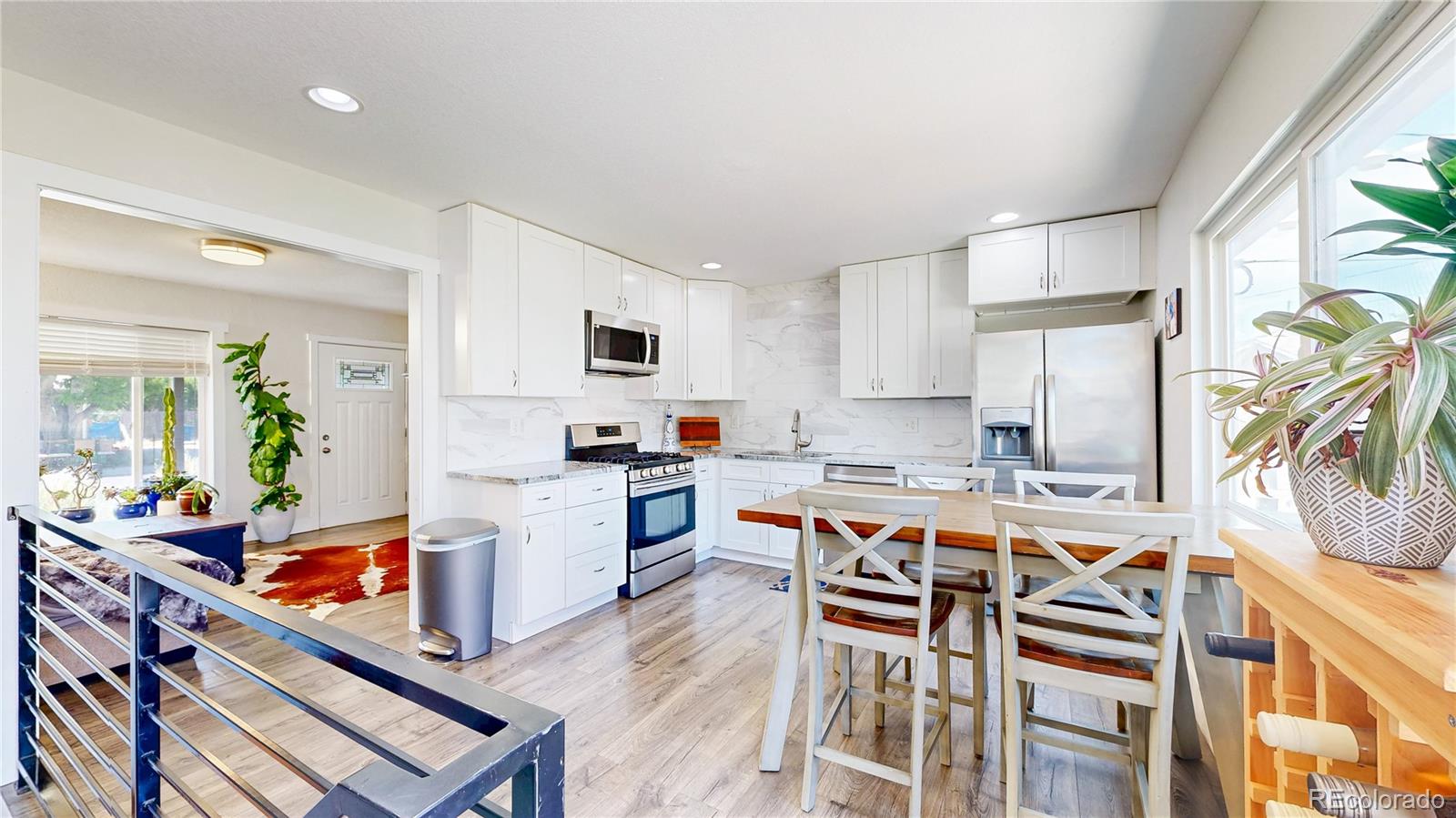 1741 West 55th Place Denver, CO 80221 - Photo 5 of 36 a kitchen with a table chairs stove and cabinets