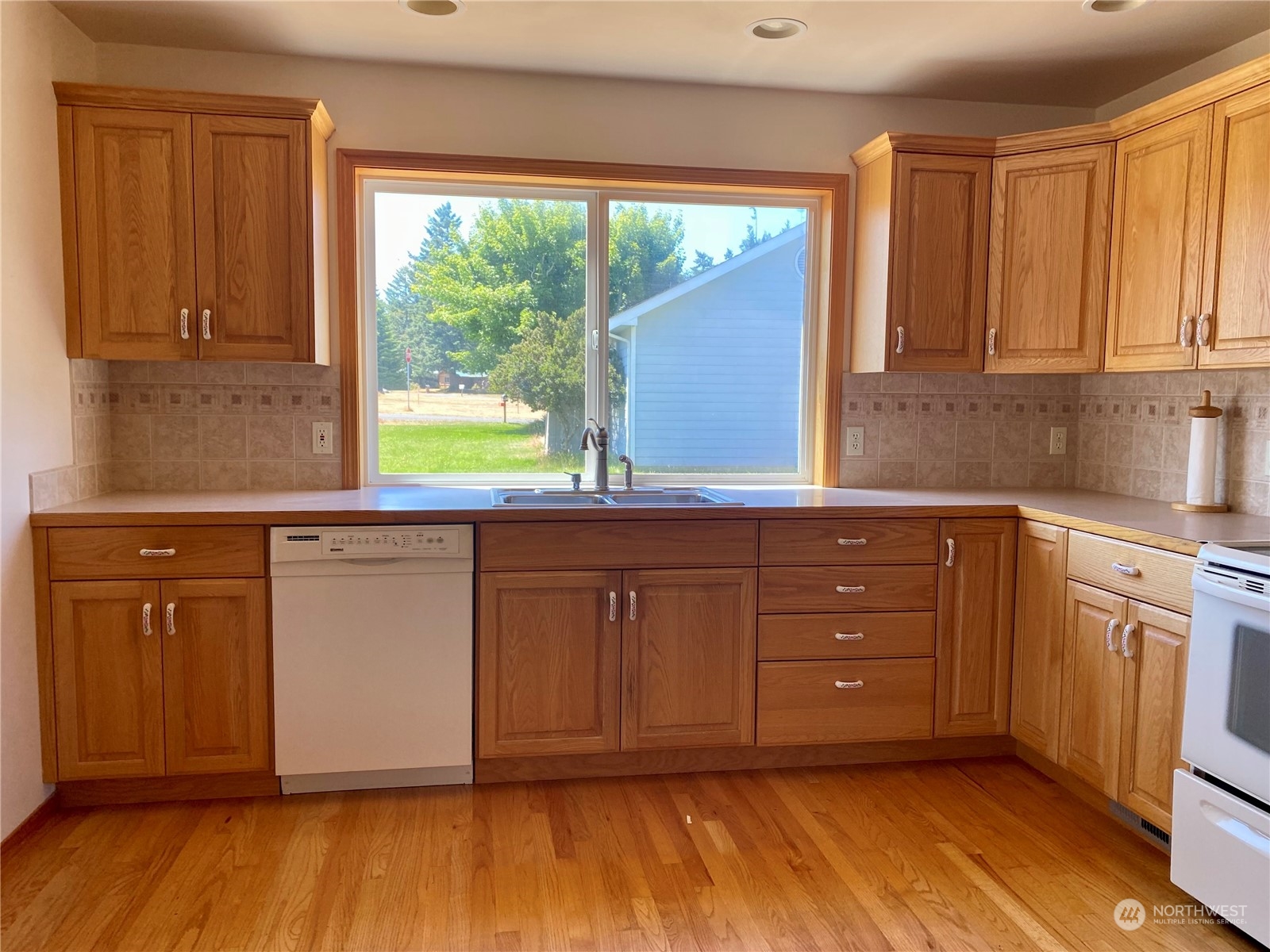 130 Cline Road Sequim, WA 98382 - Photo 16 of 35 a kitchen with granite countertop wooden cabinets a sink and a window