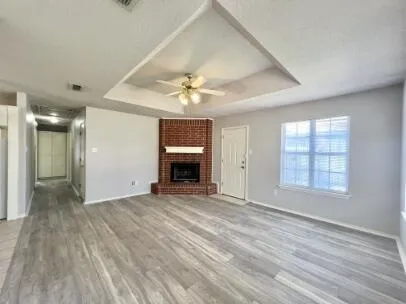 a view of an empty room with a window and fireplace