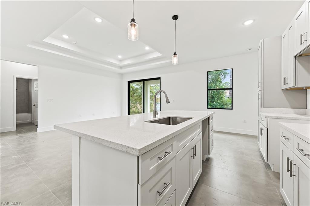 3705 37th Street Southwest Lehigh Acres, FL 33976 - Photo 15 of 35 a kitchen with a stove a sink a refrigerator and windows