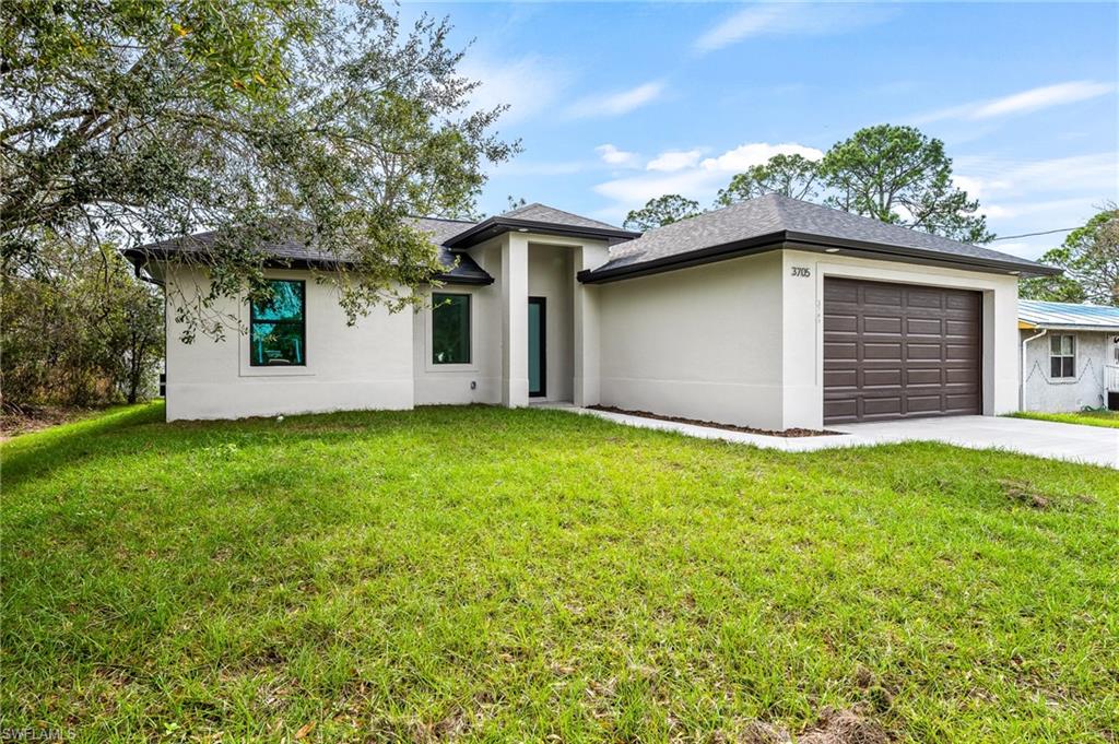 3705 37th Street Southwest Lehigh Acres, FL 33976 - Photo 2 of 35 front view of a house with a yard