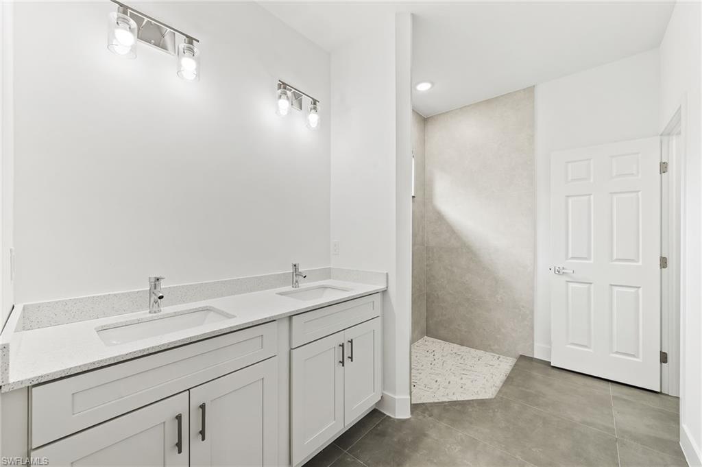 3705 37th Street Southwest Lehigh Acres, FL 33976 - Photo 25 of 35 a bathroom with a double vanity sink and mirror