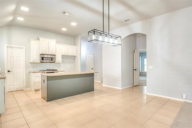 a large kitchen with cabinets and stainless steel appliances
