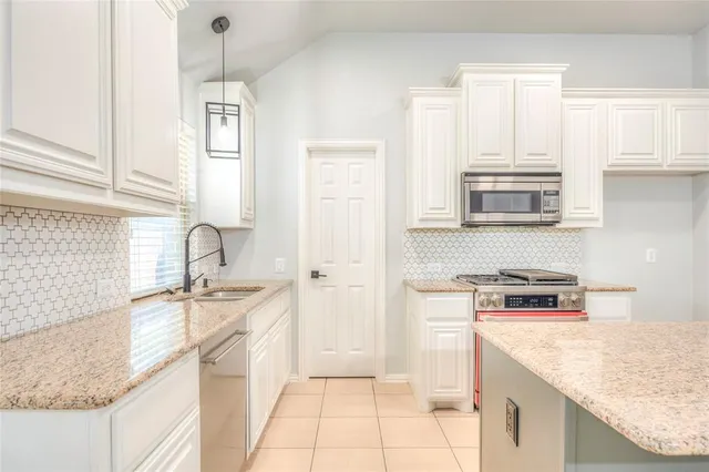a kitchen with stainless steel appliances granite countertop a sink stove and cabinets
