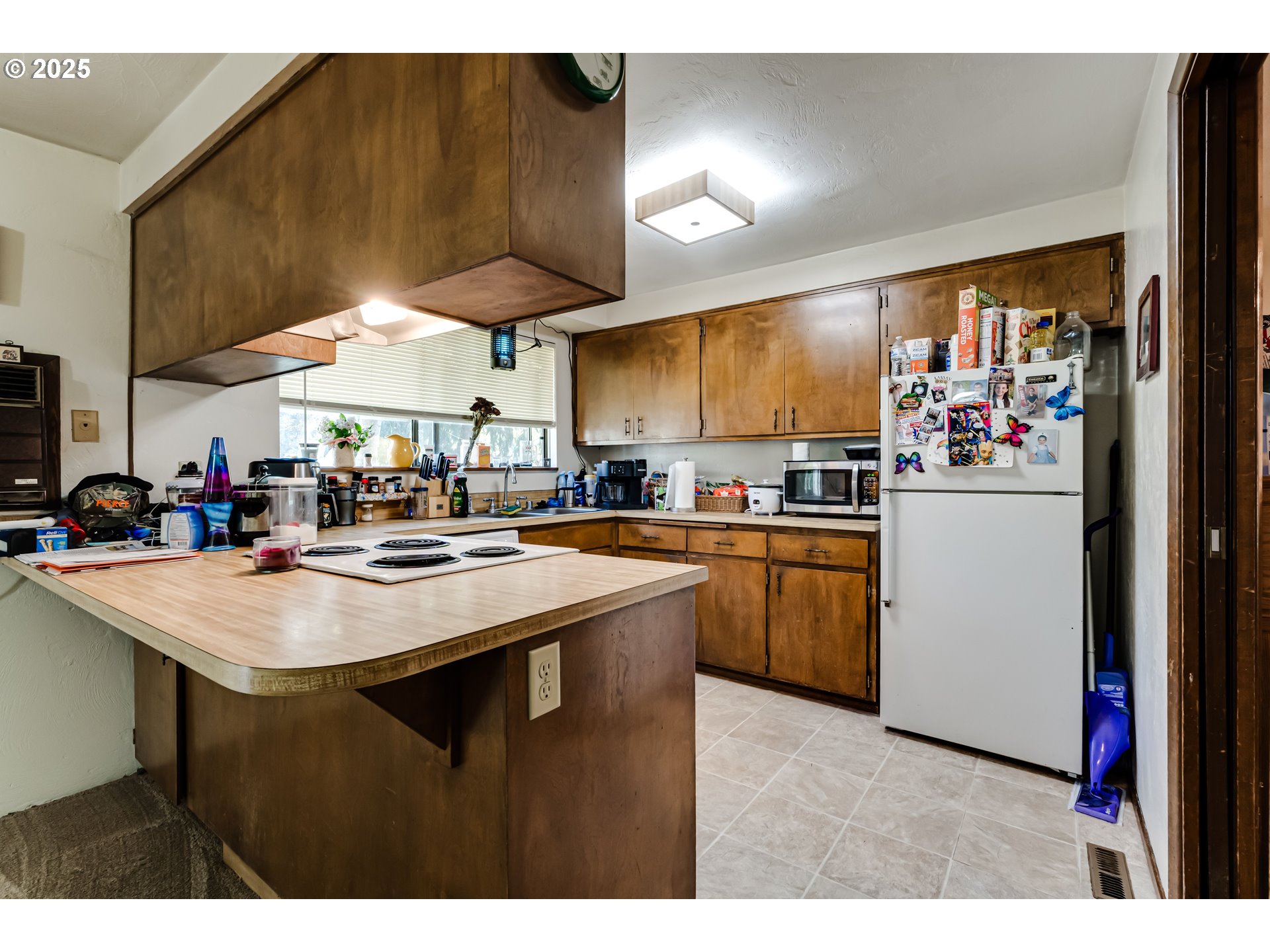 3911 Pam Street Eugene, OR 97402 - Photo 8 of 25 a kitchen with kitchen island a sink a stove and a refrigerator