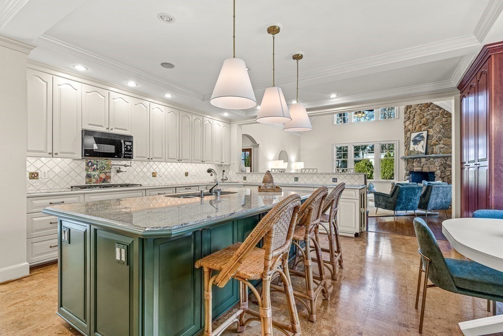 47 Cypress Road Wellesley, MA 02481 - Photo 11 of 36 a kitchen with stainless steel appliances granite countertop a stove a refrigerator a kitchen island a dining table and chairs with wooden floor