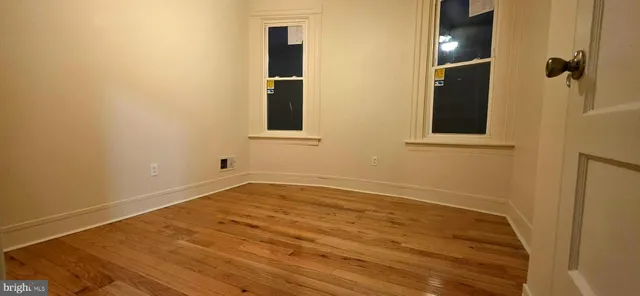 a view of empty room with wooden floor