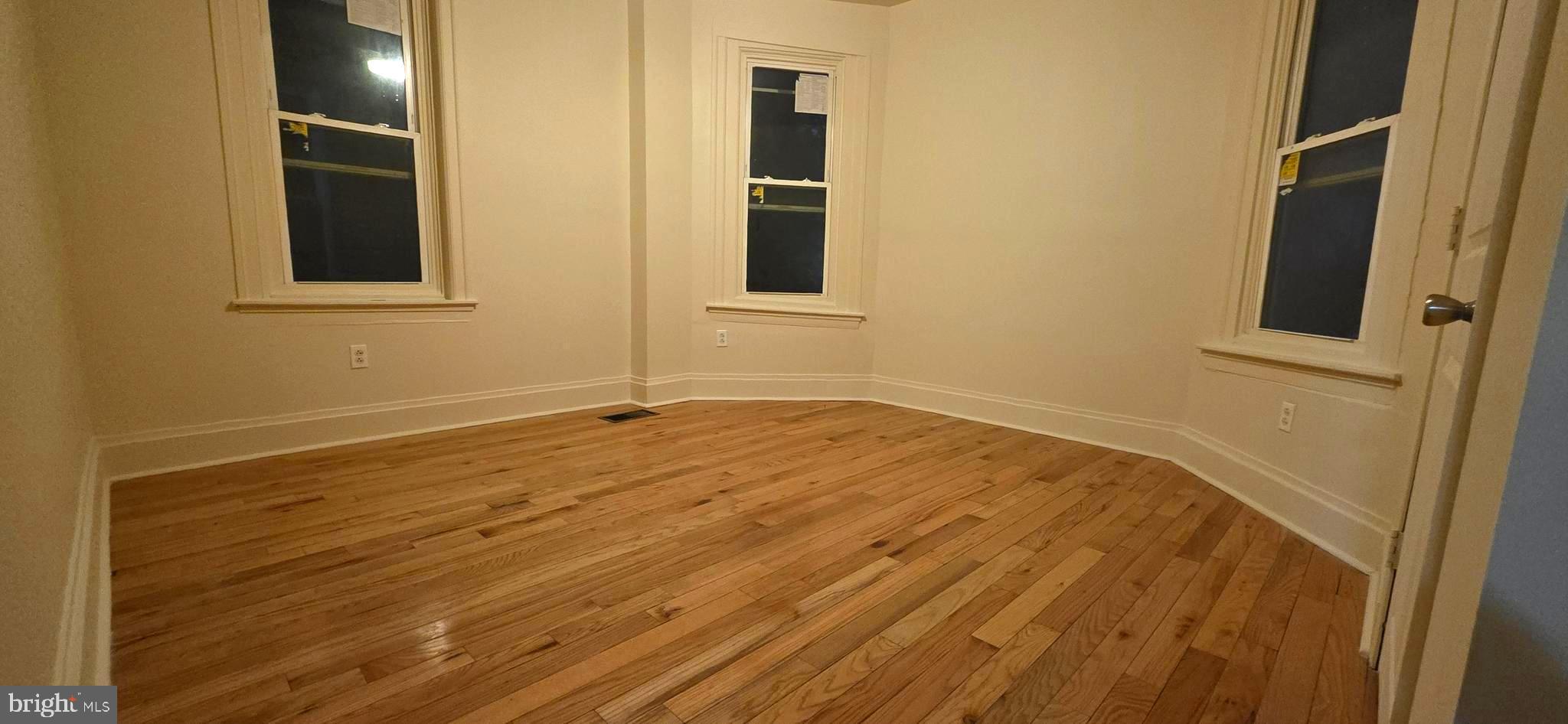 4527 North Carlisle Street Philadelphia, PA 19140 - Photo 26 of 28 a view of an empty room with wooden floor and windows