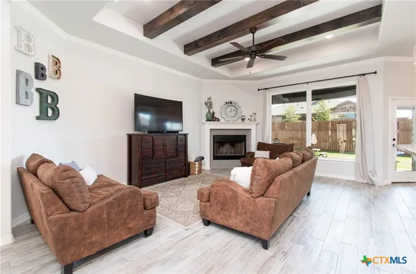 a living room with furniture a flat screen tv and a fireplace