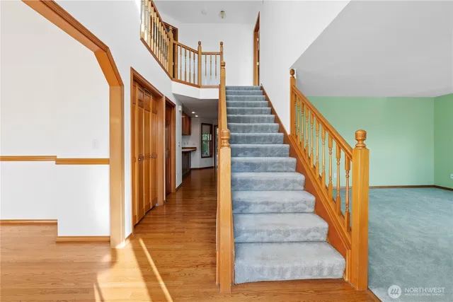 a view of staircase with lots of frames on wall and a large window