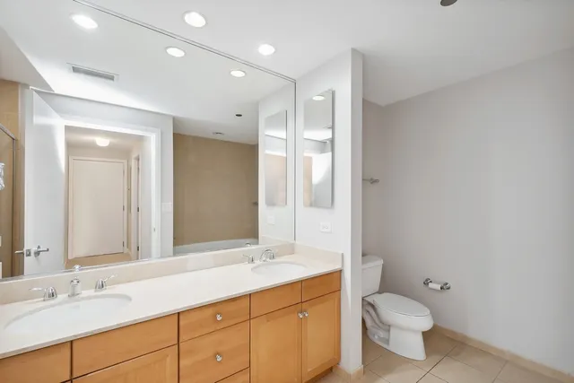 a bathroom with a tub sink shower and two mirror