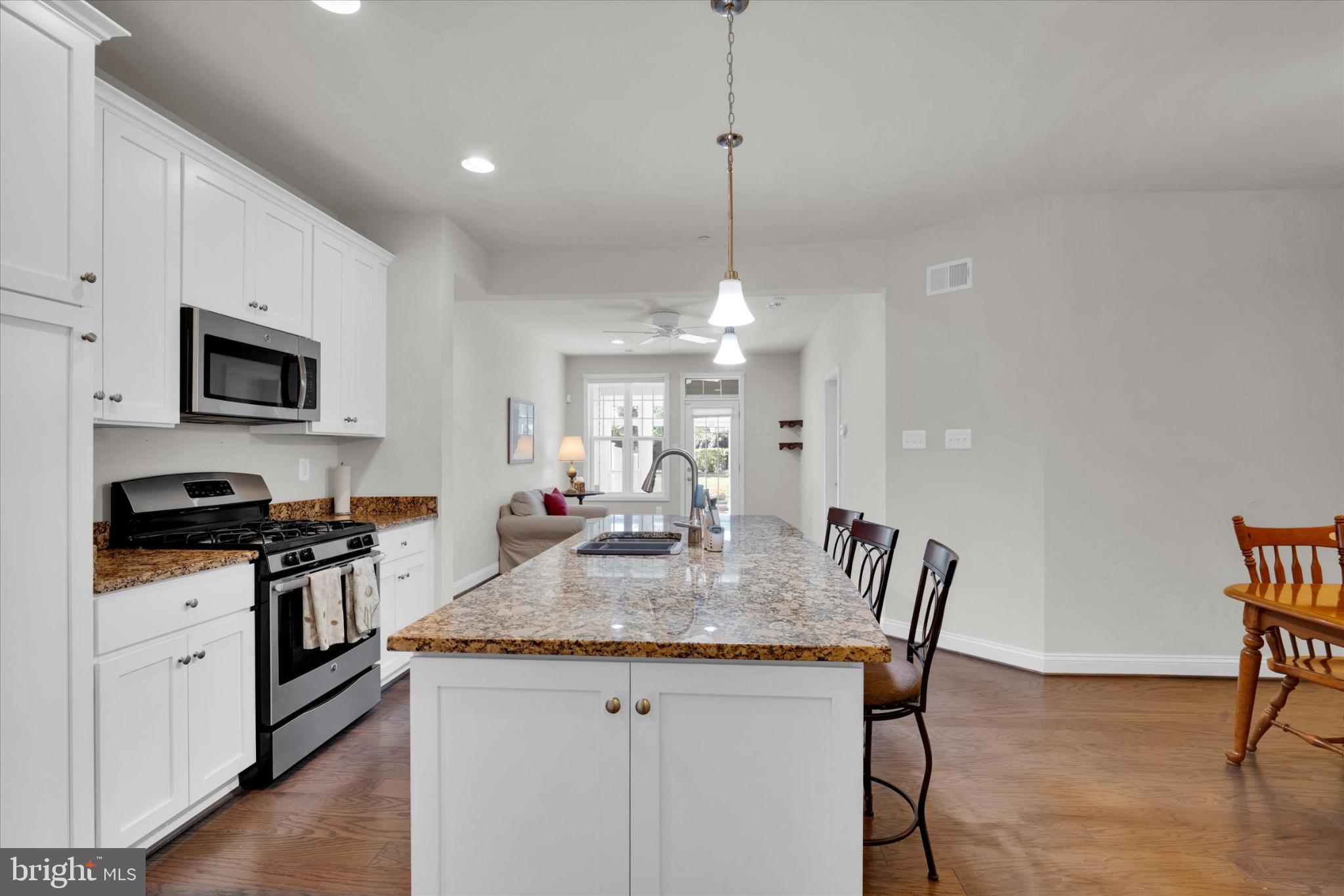 1219 Beaver Tree Drive Odenton, MD 21113 - Photo 6 of 48 a view of a kitchen with granite countertop stove a sink a dining table and chairs