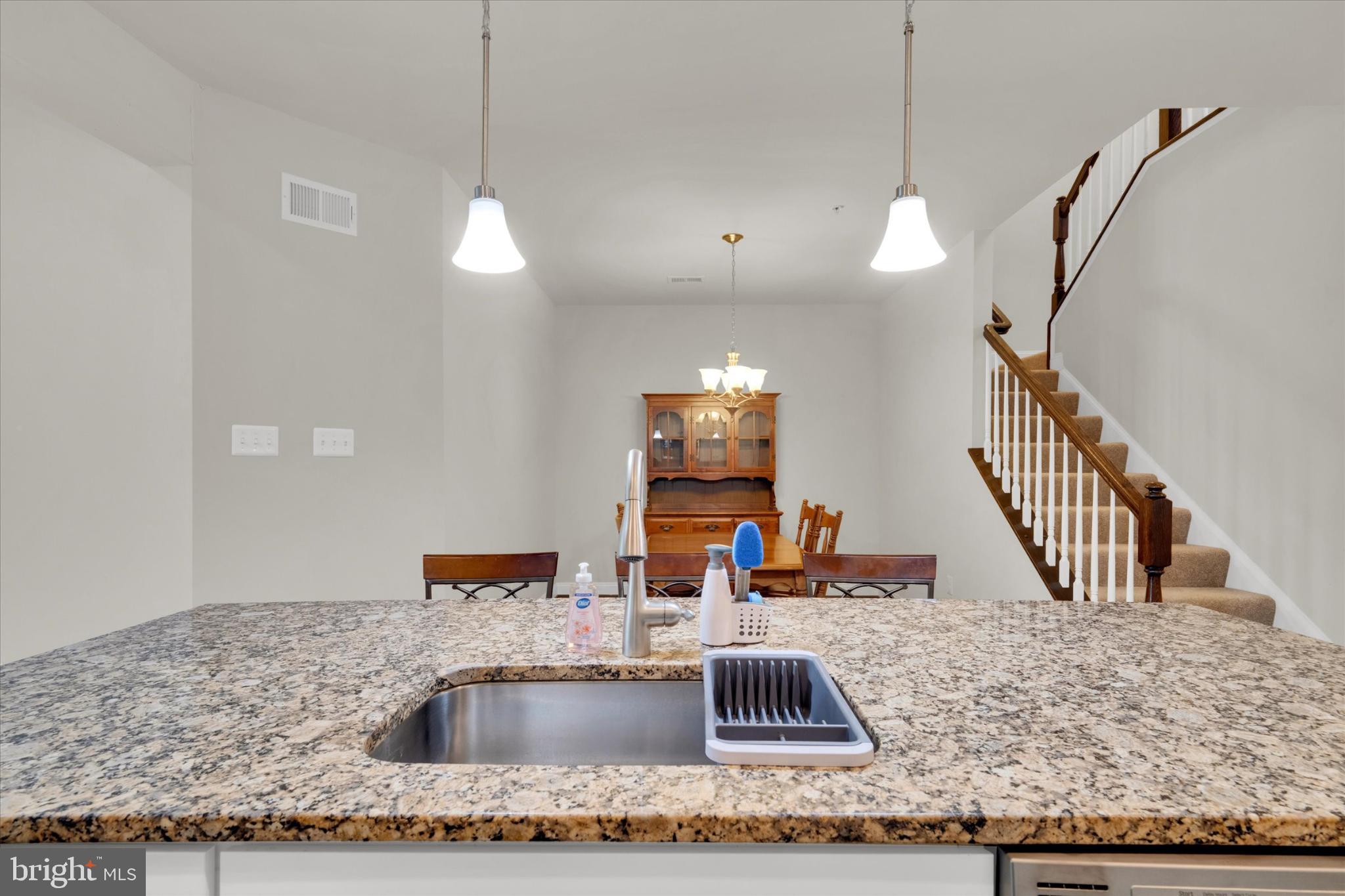 1219 Beaver Tree Drive Odenton, MD 21113 - Photo 7 of 48 a kitchen with kitchen island a sink granite counter tops and a wooden floor