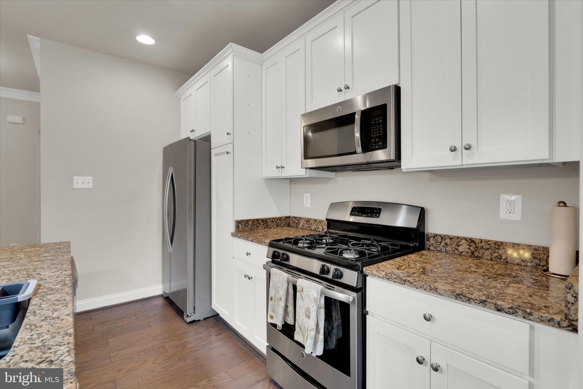 1219 Beaver Tree Drive Odenton, MD 21113 - Photo 8 of 48 a kitchen with stainless steel appliances granite countertop white cabinets and a stove a refrigerator with white cabinets