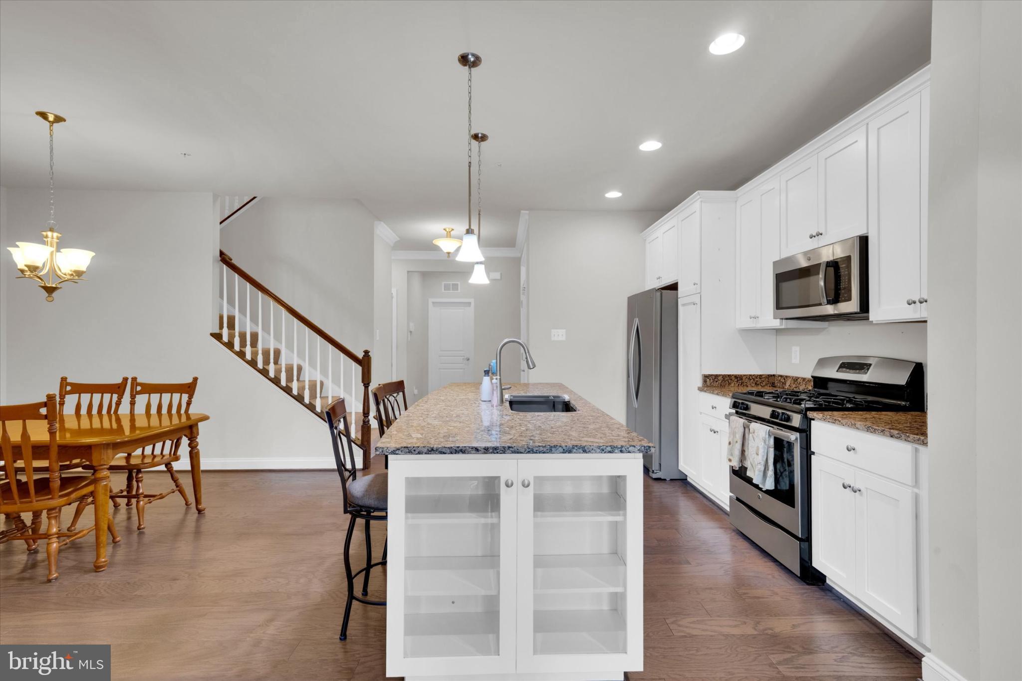 1219 Beaver Tree Drive Odenton, MD 21113 - Photo 9 of 48 a kitchen with stainless steel appliances granite countertop a stove top oven a refrigerator a sink and a dining table
