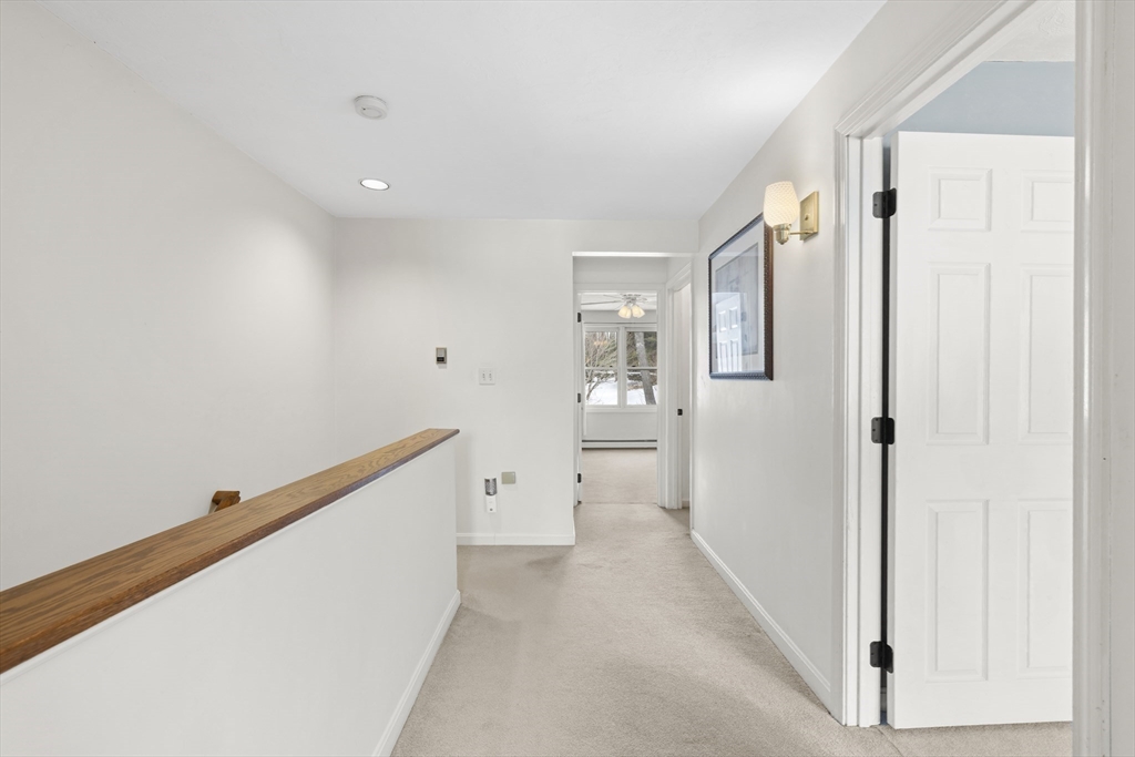 7 Fieldstone Drive, Unit 7 Upton, MA 01568 - Photo 15 of 30 a view of a hallway with wooden floor and a bathroom
