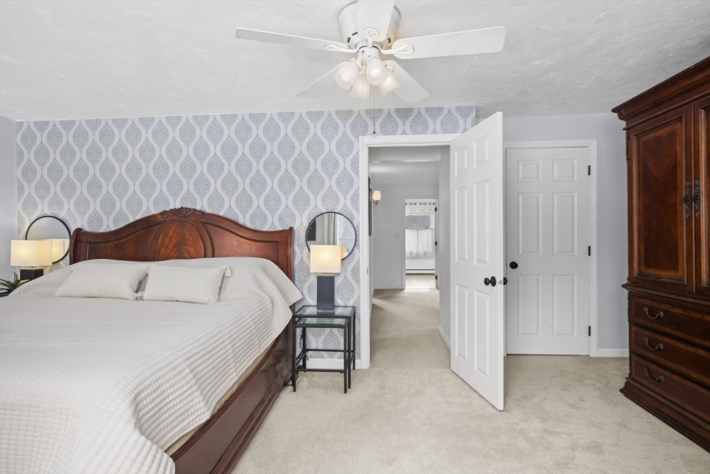 7 Fieldstone Drive, Unit 7 Upton, MA 01568 - Photo 18 of 30 a bedroom with a bed and a chandelier