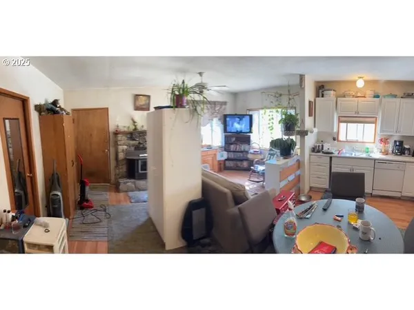 a living room with furniture a chandelier a rug and kitchen view