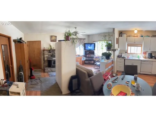 a living room with furniture a chandelier a rug and kitchen view