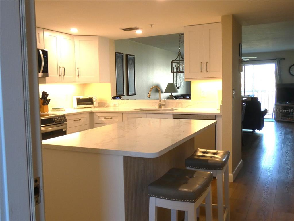 9320 Clubside Circle, Unit 2209 Sarasota, FL 34238 - Photo 2 of 27 a large kitchen with kitchen island a sink table and chairs