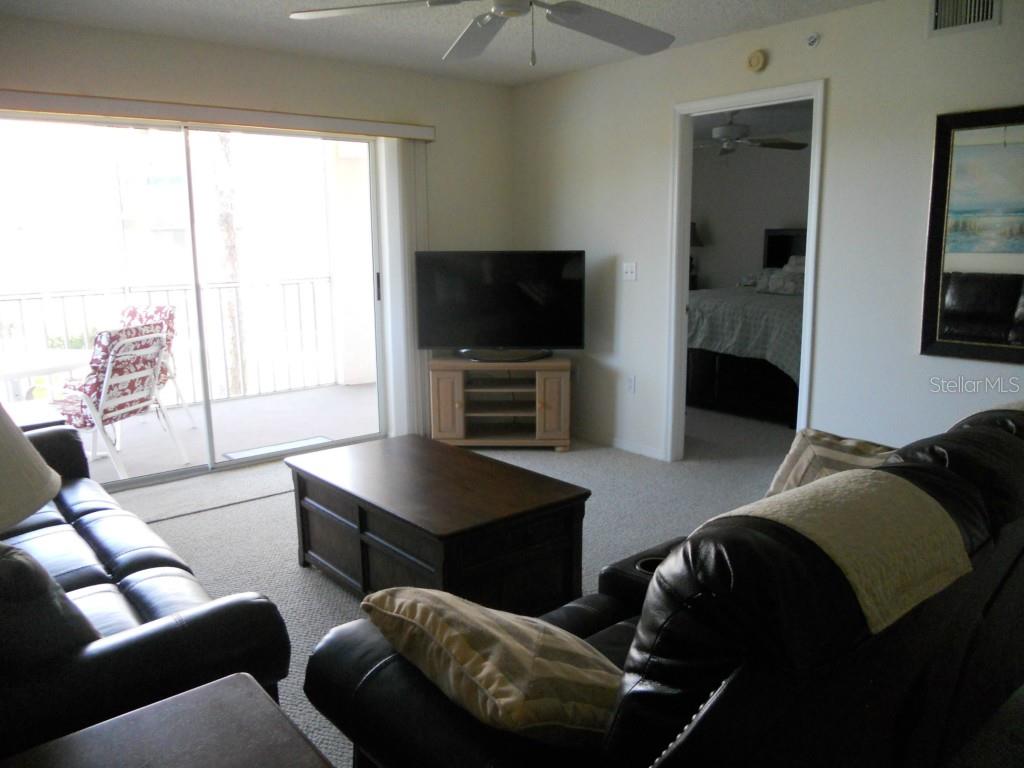 9320 Clubside Circle, Unit 2209 Sarasota, FL 34238 - Photo 8 of 27 a living room with furniture and a flat screen tv