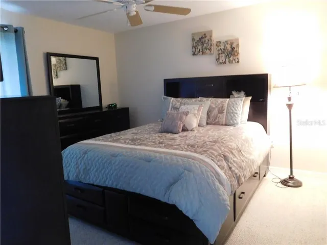 a bedroom with a bed and a painting on the wall