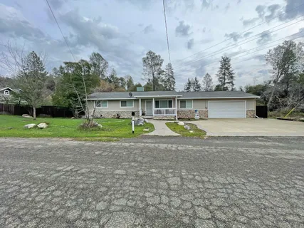 a view of a house with a yard and potted plants
