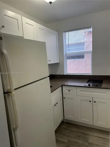 a kitchen with a refrigerator sink and cabinets