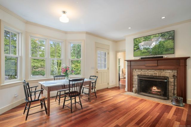 a view of a livingroom with furniture a fireplace and wooden floor