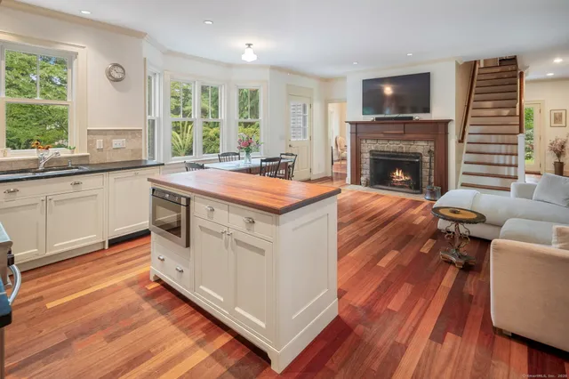 a open kitchen with cabinets stove and a wooden floor