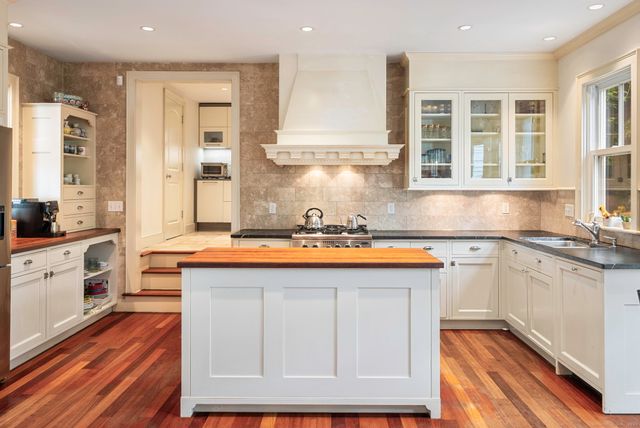 a kitchen with stainless steel appliances granite countertop a stove a sink and a refrigerator