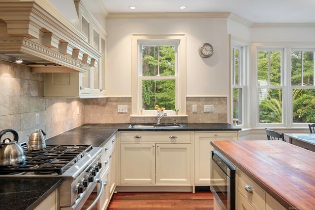 a kitchen with a sink stove top oven and cabinets