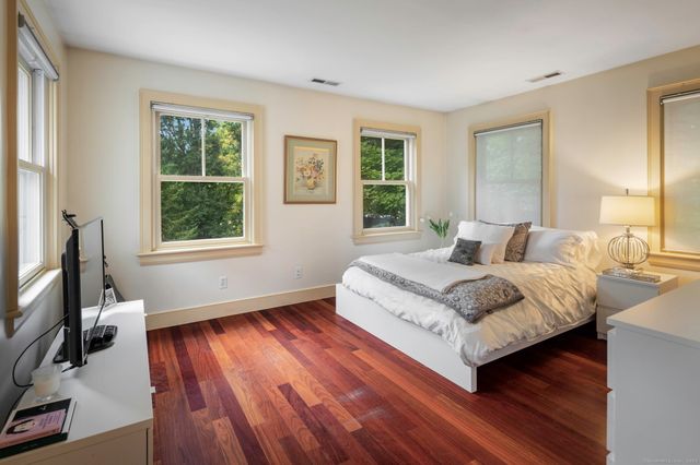 a bedroom with a bed and a flat tv screen on the dresser
