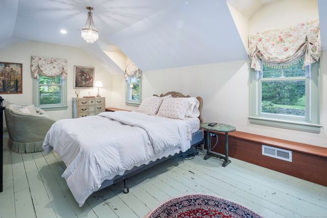a spacious bedroom with a large bed and a chandelier