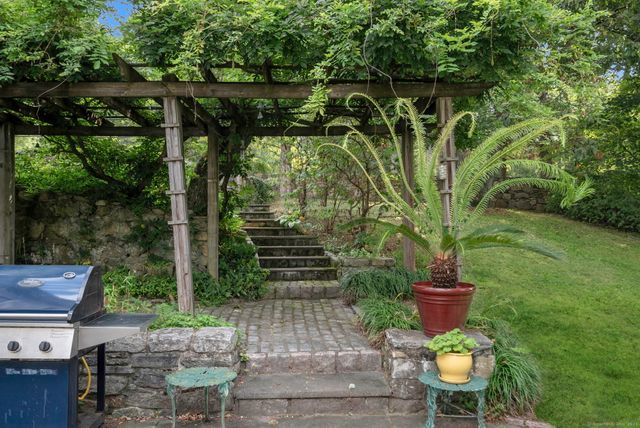 a view of a chair and table in backyard of the house