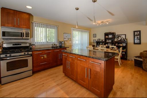 230 North Ela Road Barrington, IL 60010 - Photo 4 of 16 a kitchen with stainless steel appliances granite countertop a stove top oven a sink dishwasher a dining table and chairs with wooden floor