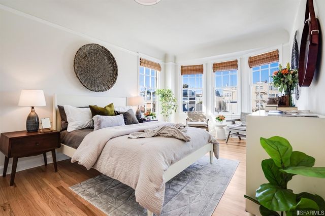 a bedroom with bed a mirror and a potted plant