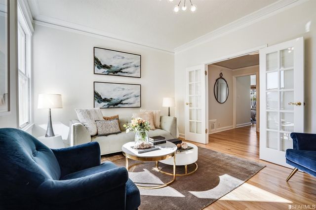 a living room with furniture a clock on wall and a window