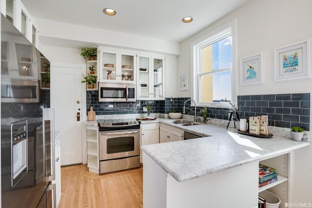a kitchen with stainless steel appliances granite countertop a stove a sink and a refrigerator