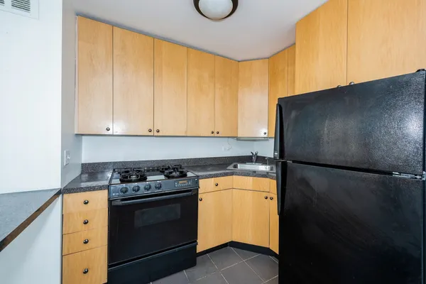 a kitchen with a refrigerator a stove and cabinets