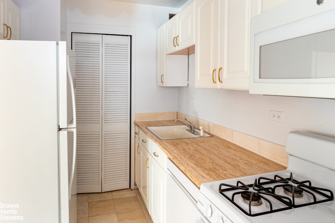 315 East 70th Street, Unit 8G Manhattan, NY 10021 - Photo 10 of 16 a kitchen with a stove and a cabinets