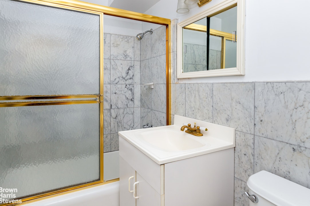 315 East 70th Street, Unit 8G Manhattan, NY 10021 - Photo 11 of 16 a bathroom with a sink a toilet and shower