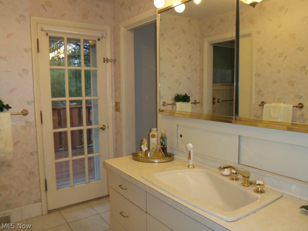 7371 Button Road Mentor, OH 44060 - Photo 17 of 25 THE ATTACHED BATH FEATURES A TILED WALK IN SHOWER AND A DOOR THAT OPENS TO A DECK WITH A HOT TUB. ENJOY WINTER WITH JUST A FEW STEPS TO YOUR HOT TUB AND LUXURIATE WHILE ENJOYING THE WOODED SURROUNDINGS.