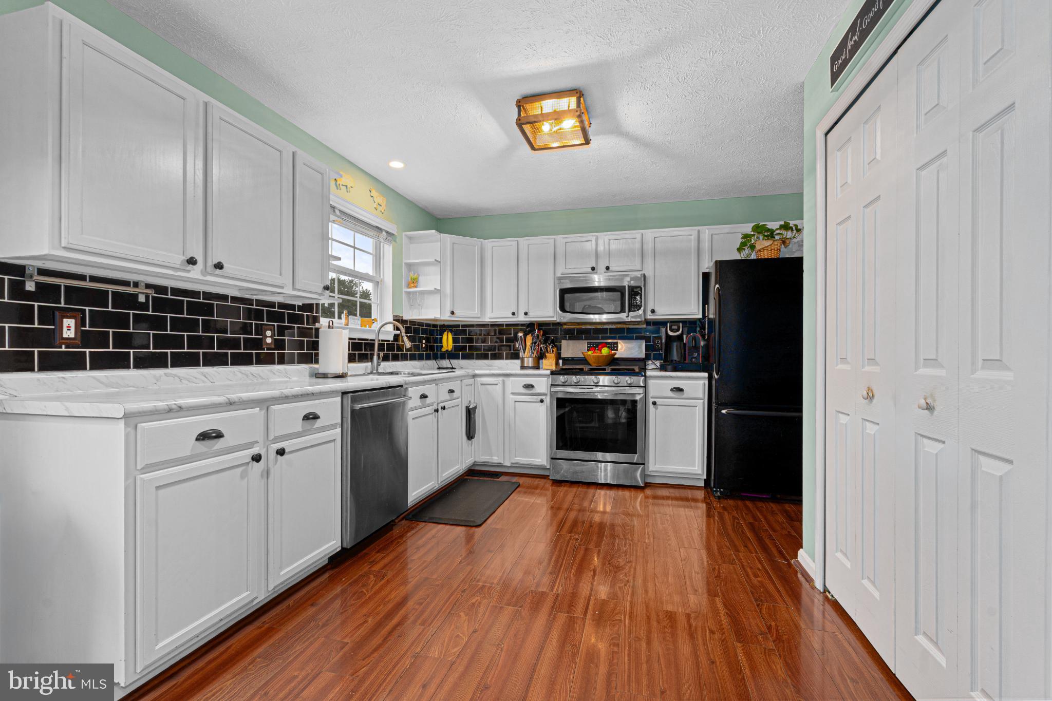 4635 Greencove Circle Sparrows Point, MD 21219 - Photo 19 of 48 a kitchen with granite countertop white cabinets and stainless steel appliances