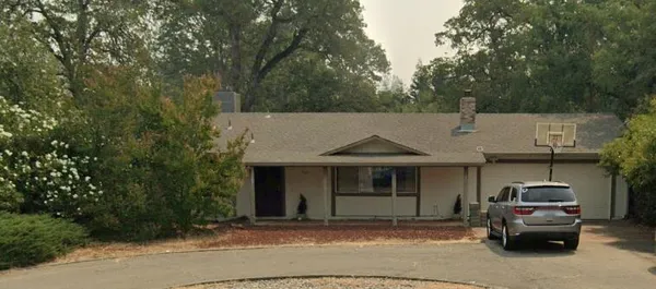 a front view of a house with cars parked