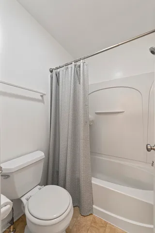 a white toilet sitting next to a bath tub and a shower