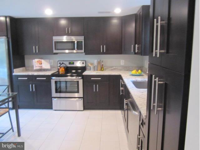 109 Sunnyside Road Silver Spring, MD 20910 - Photo 5 of 23 a kitchen with stainless steel appliances granite countertop a sink stove and refrigerator