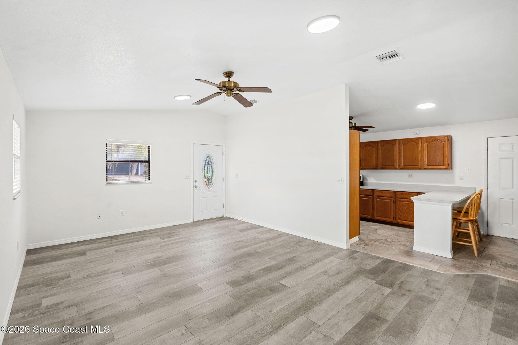 5 Lee Street Cocoa, FL 32926 - Photo 6 of 29 wooden floor in an empty room with a kitchen